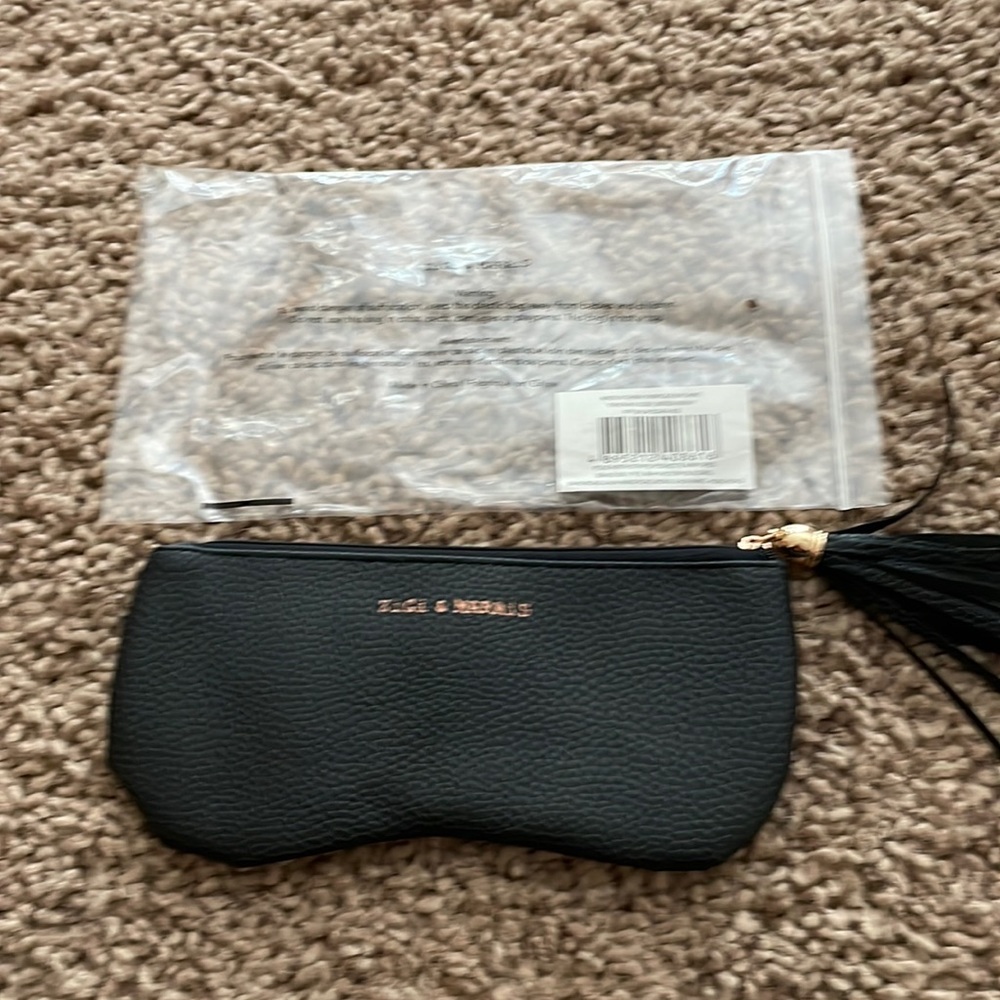 New in package ,  ZiGi & Marais faux leather pouch. Zippered with tassel